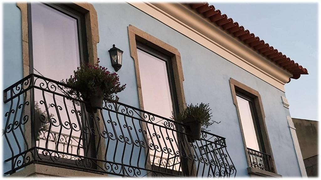 a building with a balcony with potted plants on it at Alvorada Medieval, AL in Valença