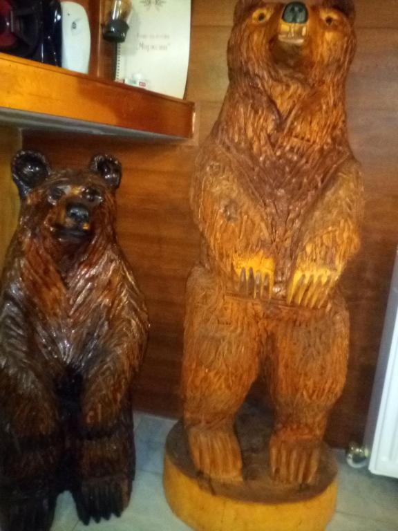 two wooden bears sitting next to each other at Guest House Markovi in Govedartsi