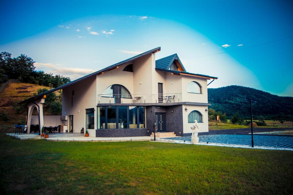 une grande maison avec une pelouse devant elle dans l'établissement Casa Ducu, à Călimăneşti