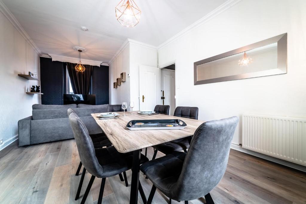 a dining room with a table and chairs and a couch at Le Centre Tenant Éternel - 3 suites in Brive-la-Gaillarde