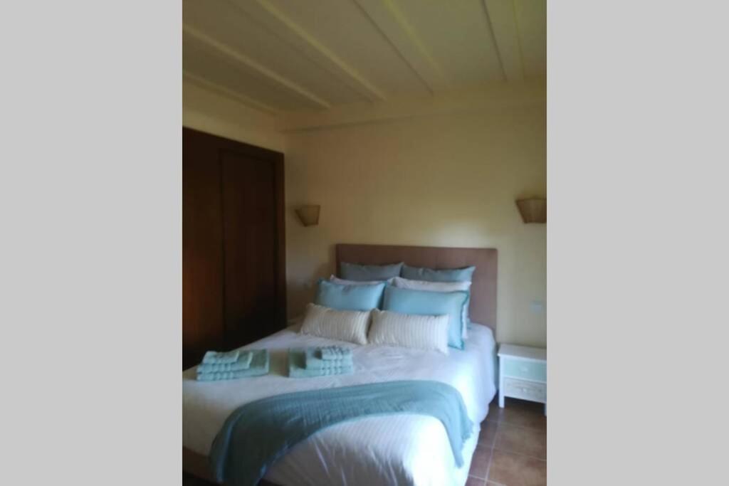 sypialnia z łóżkiem z niebiesko-białymi poduszkami w obiekcie Apartamento T2, Urbanização Golf, Isla Canela w mieście Huelva