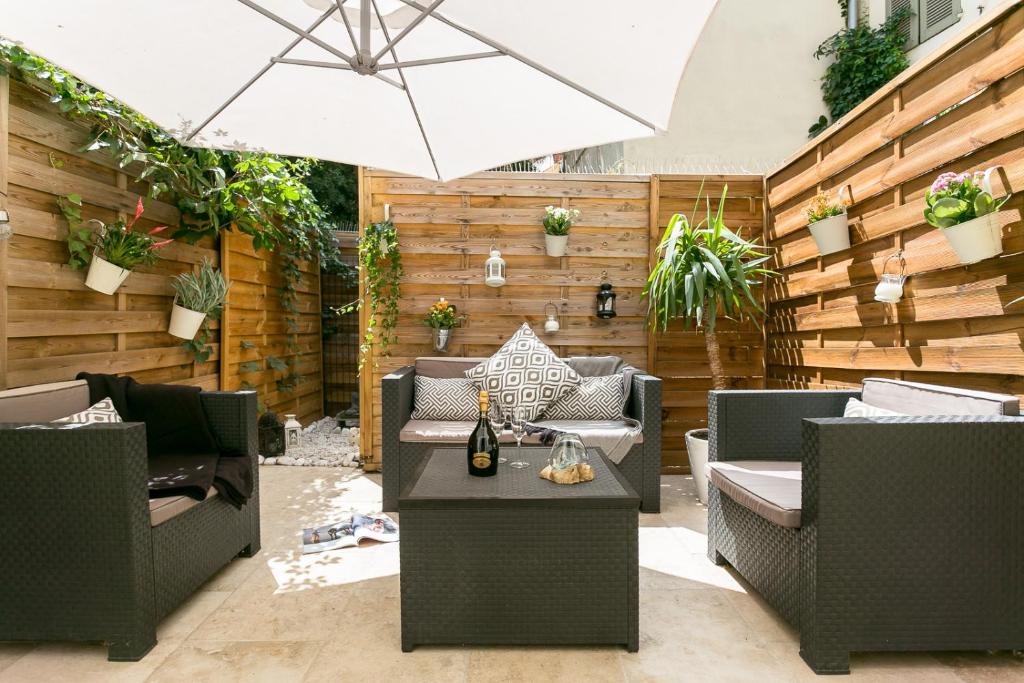 a patio with chairs and a table with an umbrella at My Pad Provence in Avignon