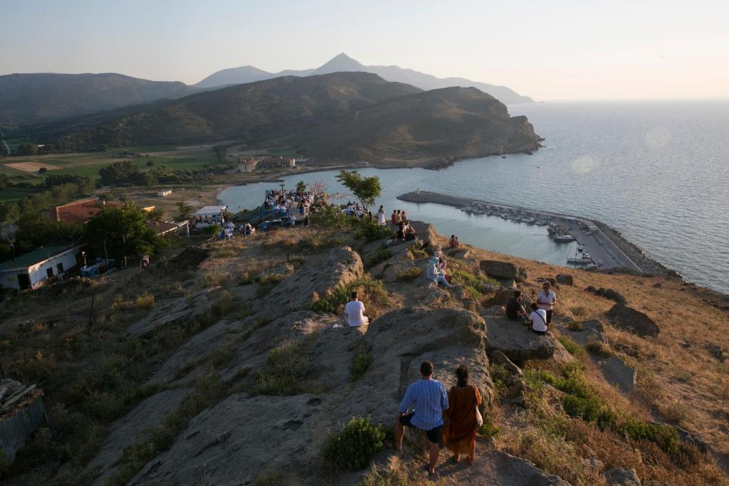 Un groupe de personnes debout sur une colline près de l'eau dans l'établissement İmroz Kardamos Hotel, à Kalekoy