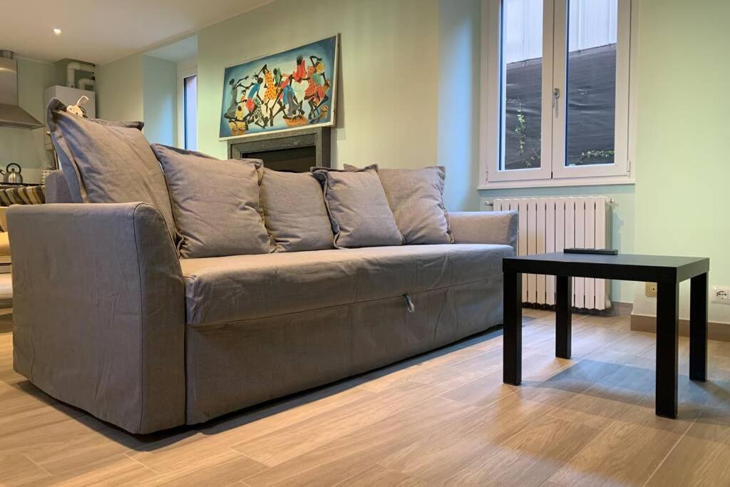 - un canapé brun dans le salon avec une table dans l'établissement Appartamento Minú, à Menaggio