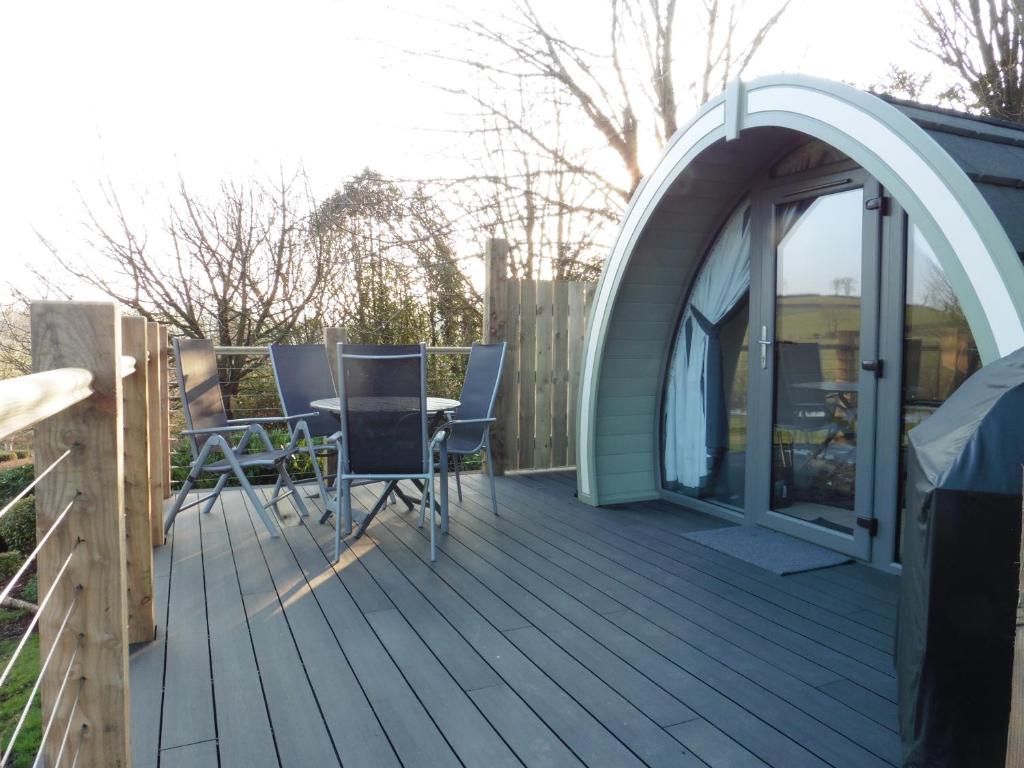 a deck with a tent and a table and chairs at Lough Erne Glamping Pod in Enniskillen