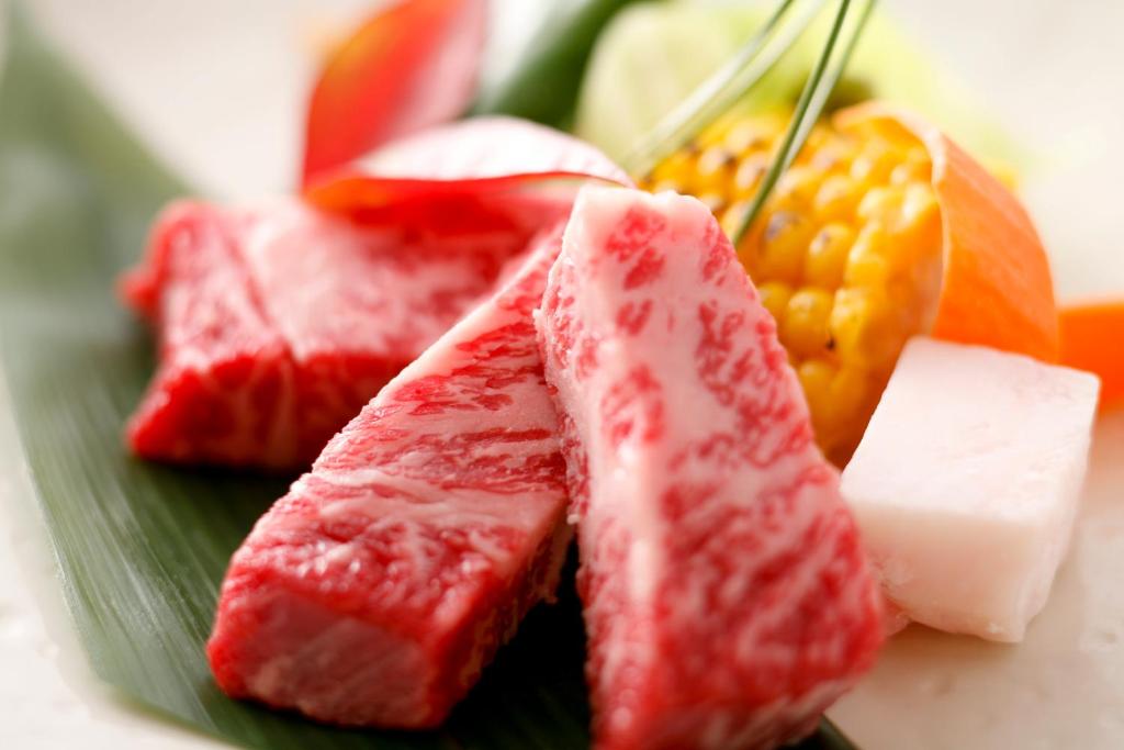 a plate of food with fruit and cheese on it at Yuraku Kinosaki Spa & Gardens in Toyooka