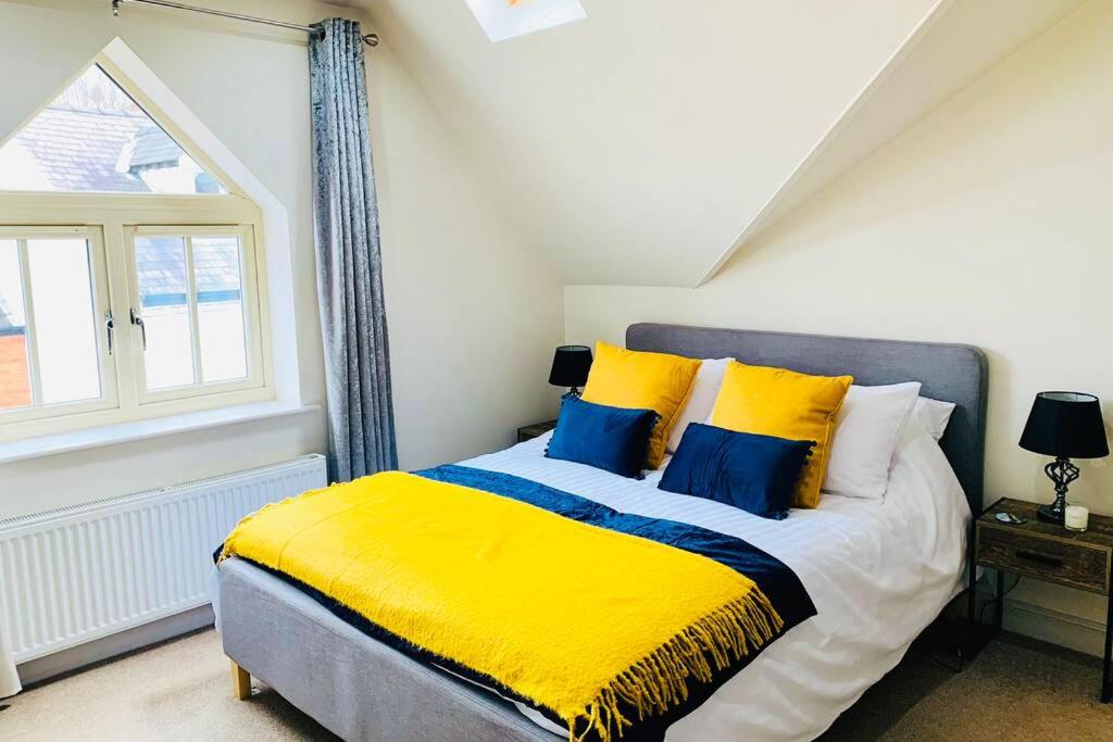1 dormitorio con 1 cama con almohadas amarillas y azules en Boutique Townhouse Uphill Lincoln, en Lincolnshire