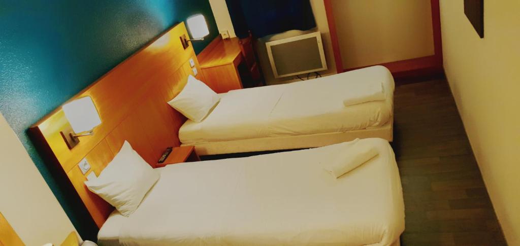 Postel nebo postele na pokoji v ubytování Glisy Hôtel