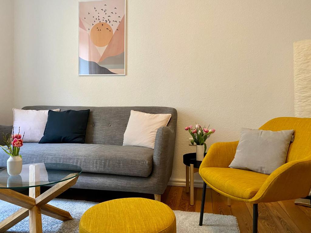 een woonkamer met een bank en 2 stoelen bij Zentrumsnahe schöne Altbauwohnung bis 4 Personen in Flensburg
