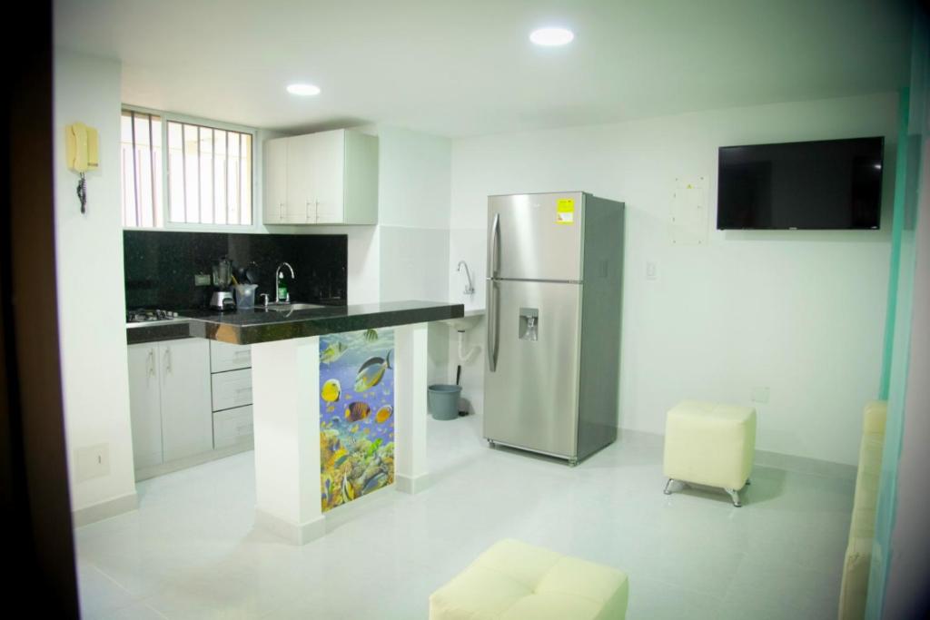 a kitchen with a stainless steel refrigerator and a sink at Apartamento Rodadero a media cuadra de la playa in Puerto de Gaira