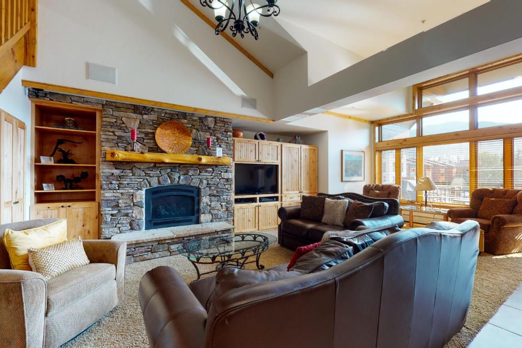 a living room with couches and a stone fireplace at Lion Square Lodge East 310 in Vail