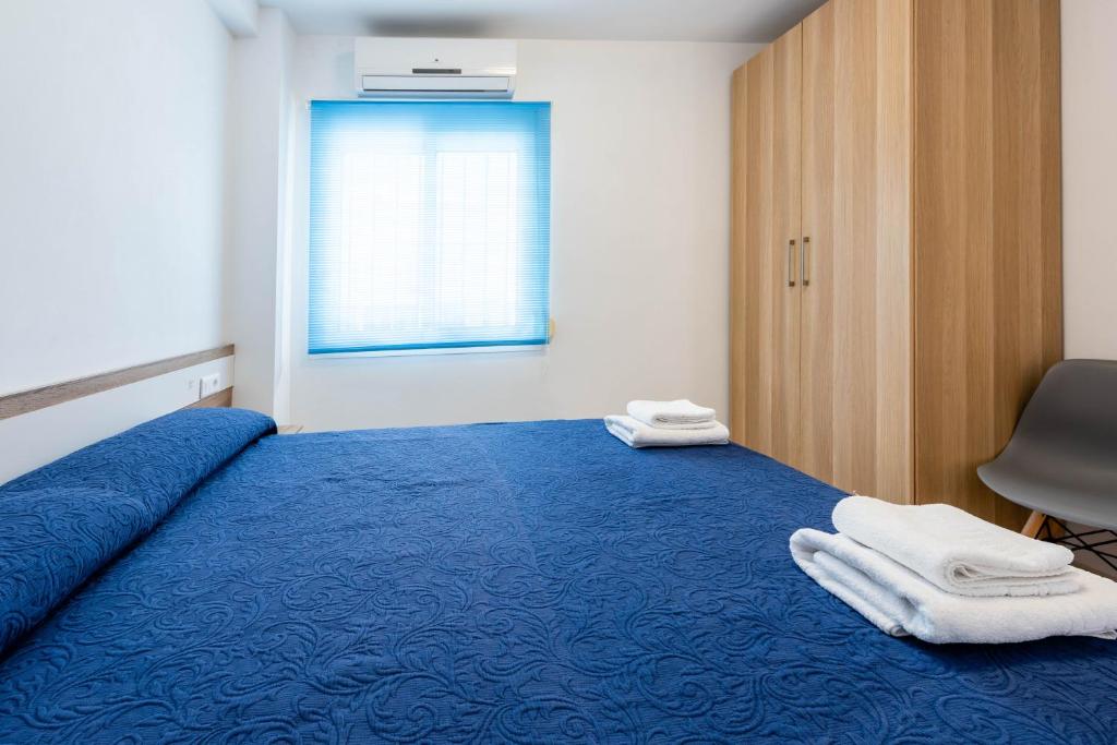 a bedroom with a blue bed with towels on it at EDIFICIO CHAPARIL in Nerja
