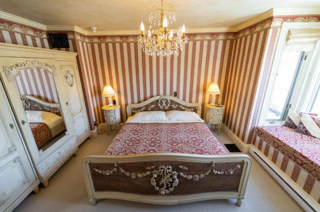 a bedroom with two beds and a chandelier at The Maple Inn in Parrsboro