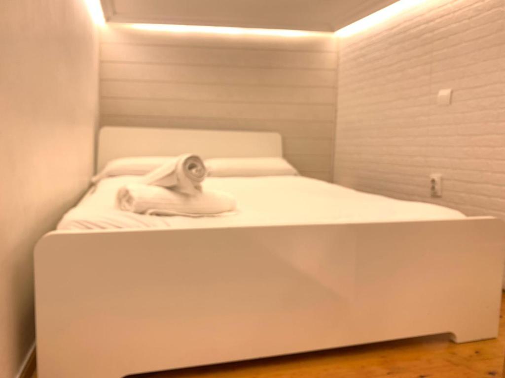 a white bed with a towel on it in a room at Mini duplex plaza mayor in Madrid