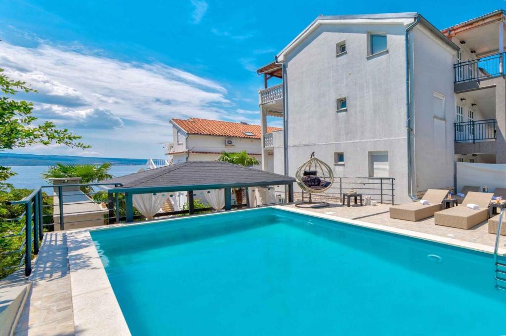 a swimming pool in the backyard of a apartment with a building at One-Bedroom Apartment in Crikvenica LX in Dramalj