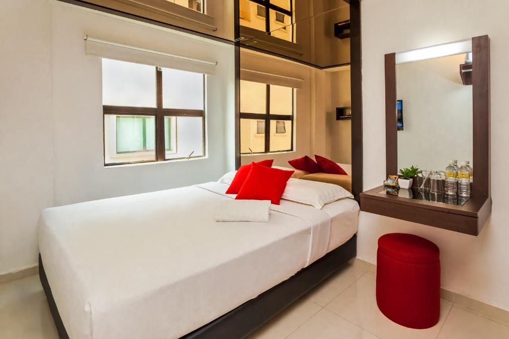 a bedroom with a large white bed with red pillows at Time Hotel Sunway in Petaling Jaya