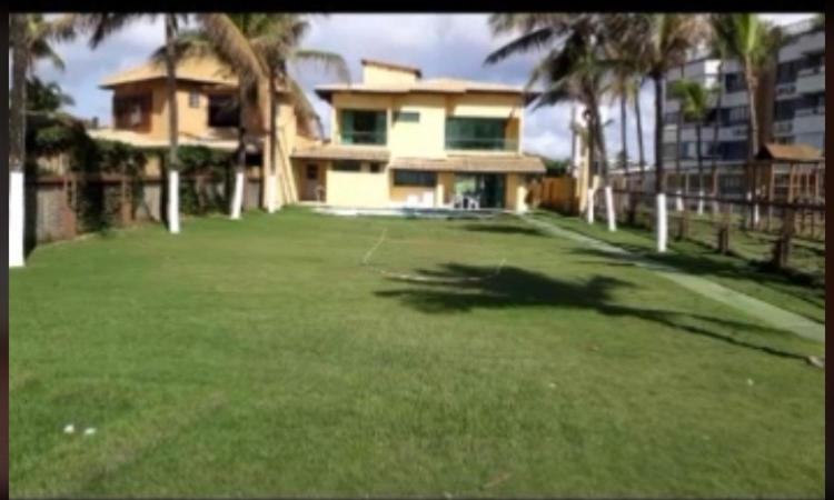 een grote tuin voor een huis met palmbomen bij Beira Mar in Salvador
