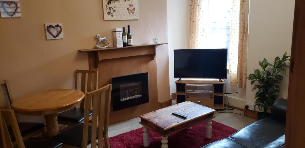 sala de estar con chimenea y TV en Jane's Cottage Free Parking, en Inverness