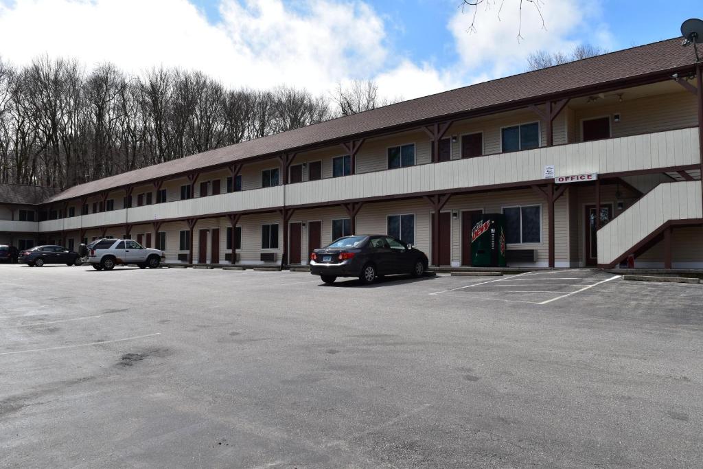 a parking lot in front of a large building at PLYMOUTH MOTOR LODGE in Terryville