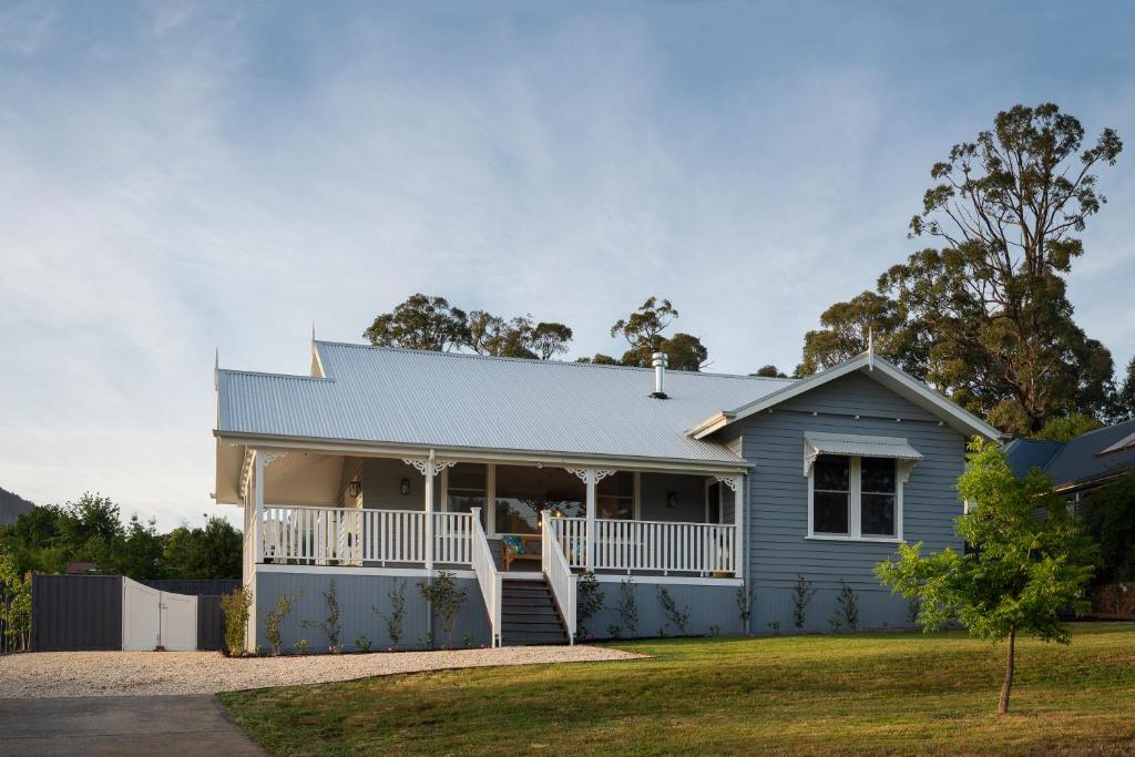 une maison bleue avec une terrasse couverte blanche et une cour dans l'établissement Marysville Luxury Villa, à Marysville