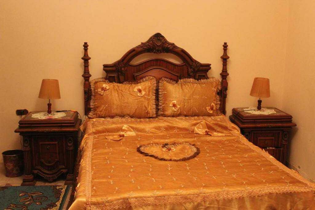 una camera da letto con un grande letto con due tavolini di Maged Pyramids View Inn a Il Cairo