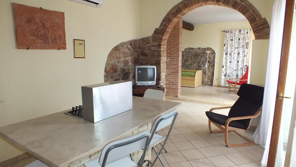un soggiorno con tavolo, sedie e TV di Vecchio Molino a Venturina Terme