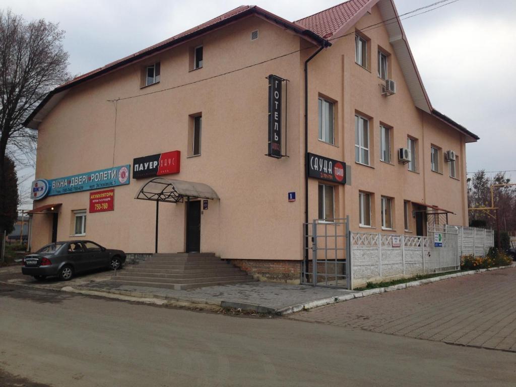 a building with a car parked in front of it at Power House Hotel in Lutsk