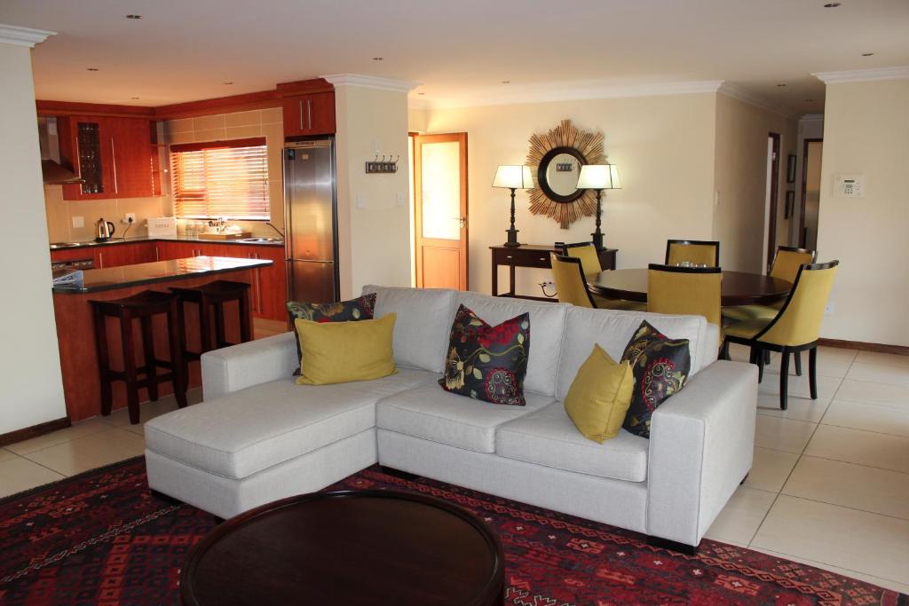 a living room with a white couch with yellow pillows at Topaz Cove Luxury Villas in Edenvale