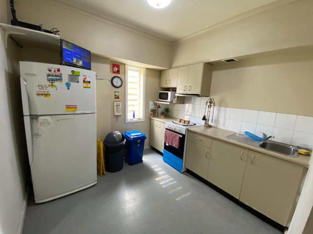 a kitchen with a white refrigerator and a sink at Cozy little room for 1 or 2 in Sydney