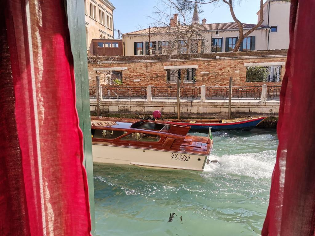 Una barca in acqua attraverso una finestra di Apartment 6518 a Venezia
