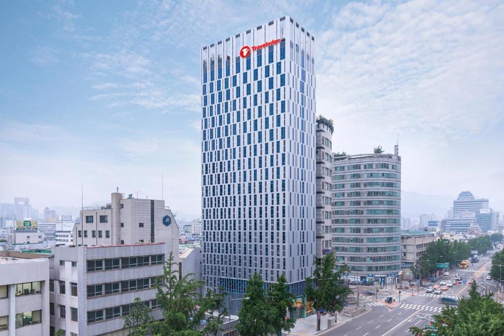 ein hohes Gebäude mit einem roten Kreis darüber in der Unterkunft Travelodge Dongdaemun Seoul in Seoul