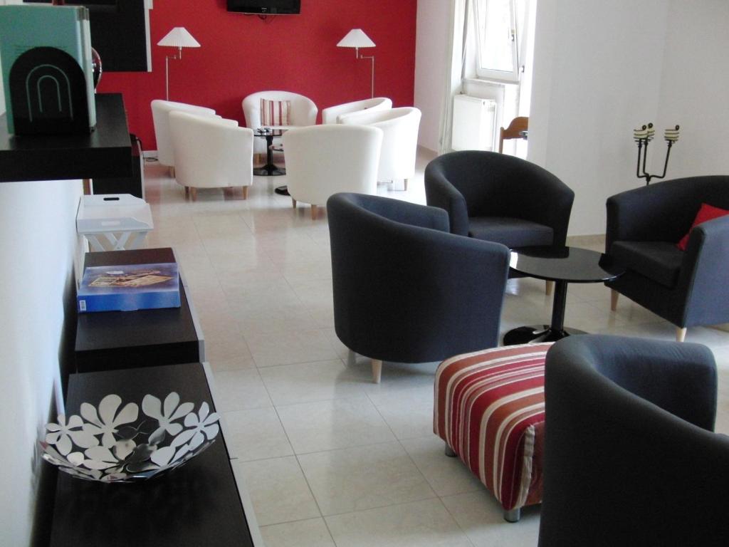 a waiting room with chairs and tables in a waiting room at ABLA Guest House in Carcavelos