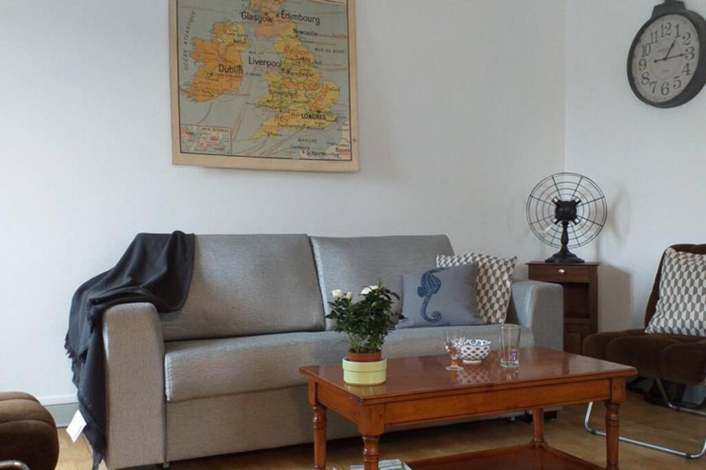sala de estar con sofá y mesa de centro en AU 13 : FENETRES SUR ARROMANCHES en Arromanches-les-Bains