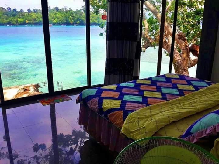 a bedroom with a bed and a view of the ocean at Mr. Bean Resort in Sabong