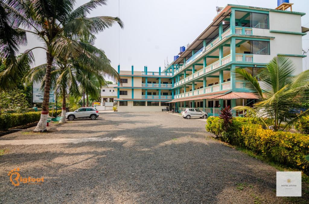 a large building with cars parked in front of it at Hotel Atithi in Kashid