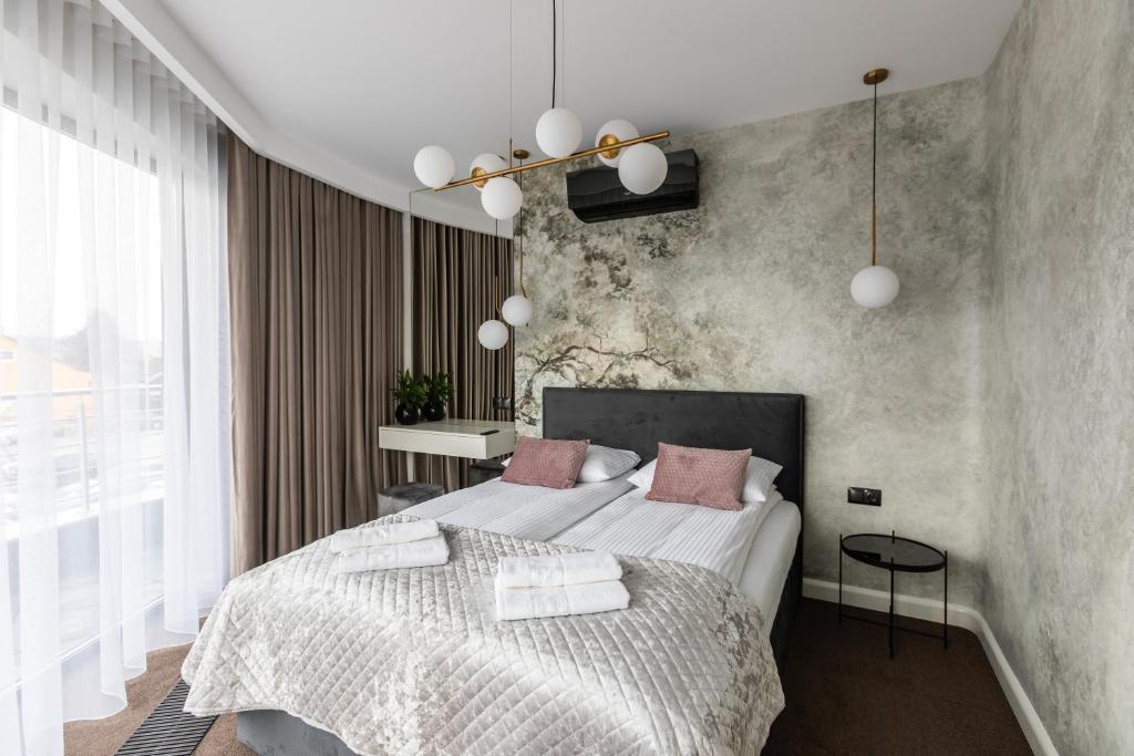 a bedroom with two beds with white sheets and pink pillows at Apartamenty Green Place in Kańczuga