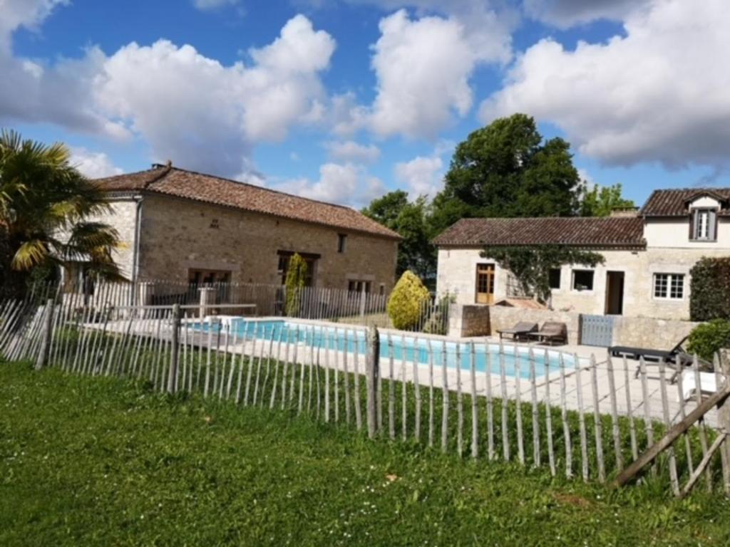 a fence around a swimming pool in front of a house at "Villa spacieuse à Sigoulès avec piscine privée" in Sigoulès