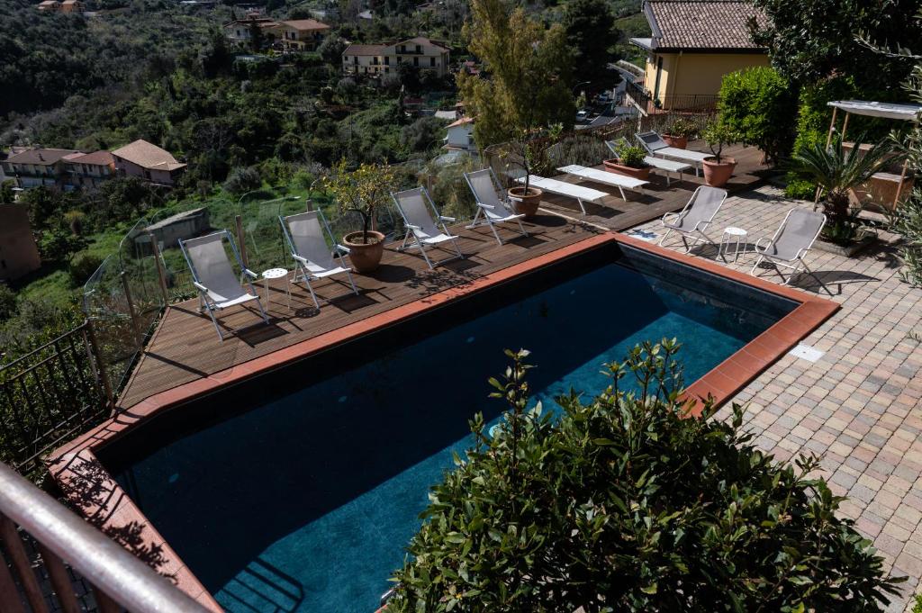a patio area with a pool, chairs, and tables at Casa Rossa in Monreale