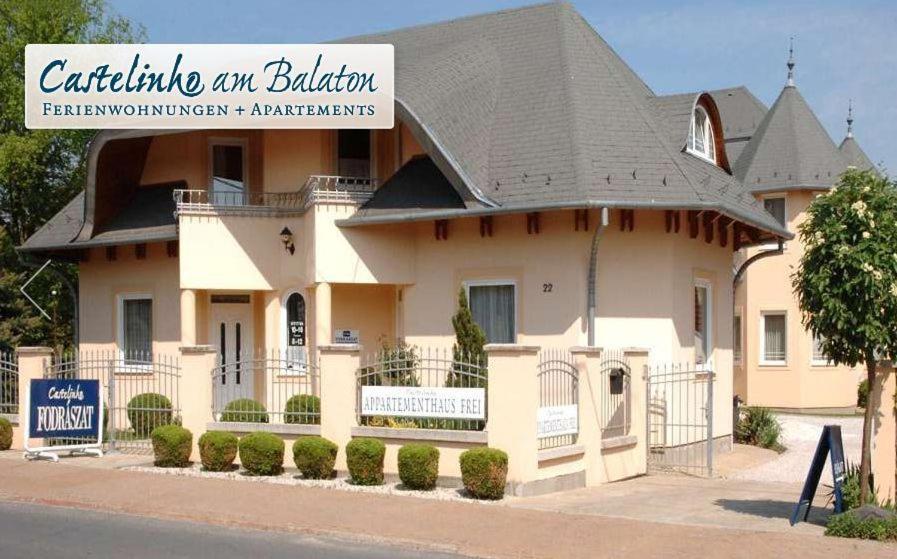 a large white house with a black roof at Castelinho Apartmanház in Gyenesdiás