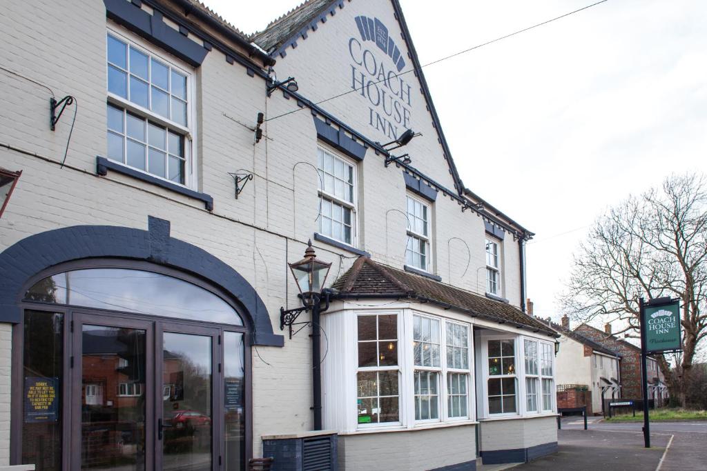 un edificio blanco con un cartel en el costado en Coach House Inn, en Dorchester