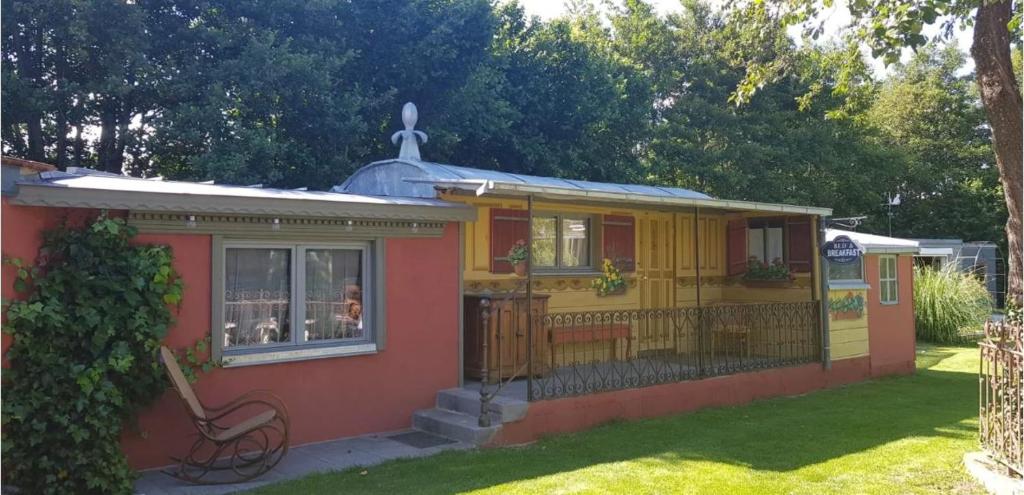 una pequeña casa amarilla y roja con patio en Le Riolet, en Marsac-en-Livradois