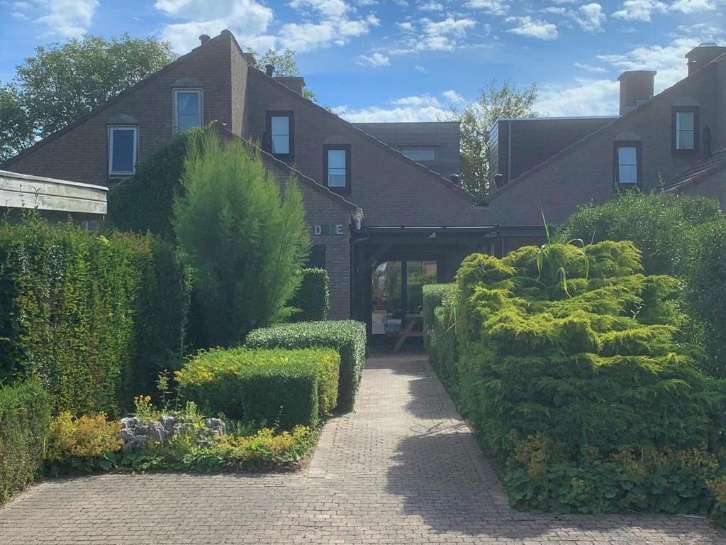 a house with bushes and hedges in front of it at Dune in Retranchement