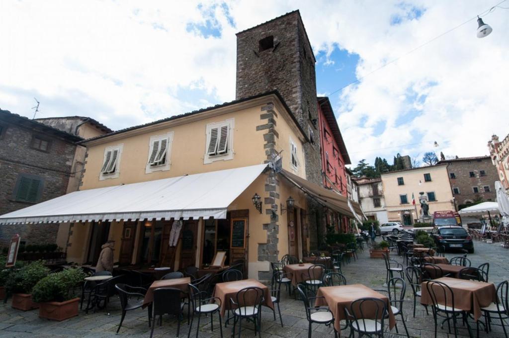 a building with tables and chairs in a street at La Torre in Montecatini Terme