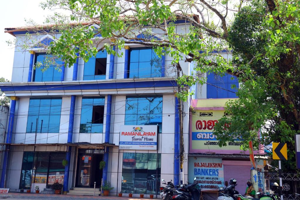 a building on a street with motorcycles parked in front at Ramanilayam Tourist Home in Ambalapulai