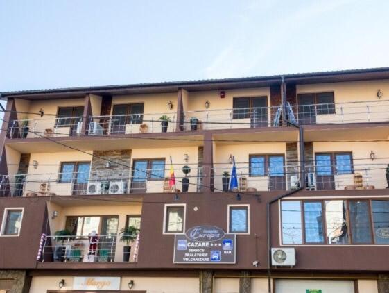 a large building with balconies and a sign on it at Pensiunea Europa in Reşiţa