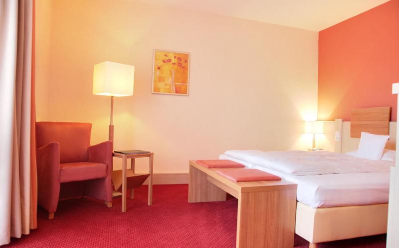 Postel nebo postele na pokoji v ubytování Hotel am Kurpark