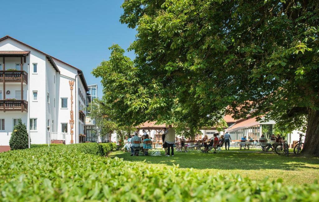a group of people in a park next to a building at Hotel Wolfringmühle in Fensterbach