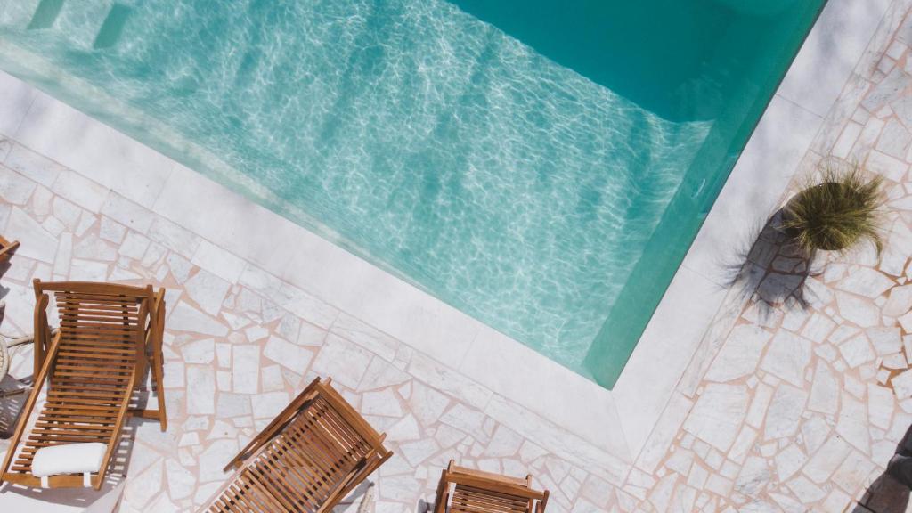 an overhead view of a swimming pool with lounges and chairs at Hôtel Le Sud in Juan-les-Pins