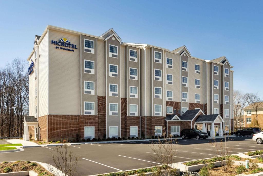 a large hotel with a parking lot in front of it at Microtel Inn & Suites by Wyndham Gambrills in Odenton