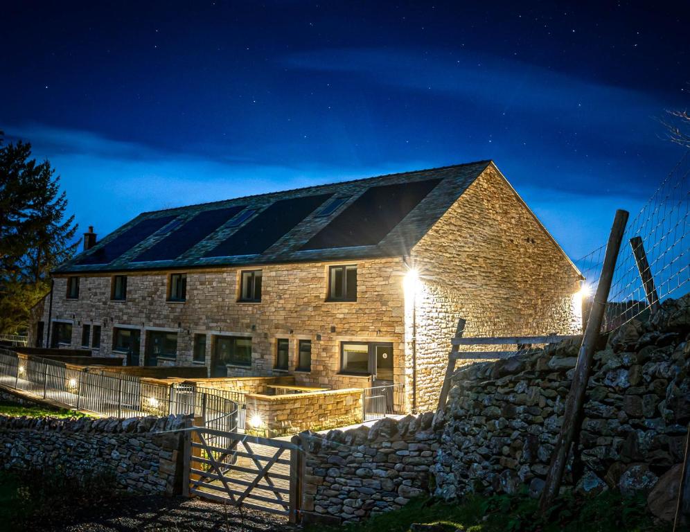 a stone barn with solar panels on the roof at night at Woodside Houses in Penrith